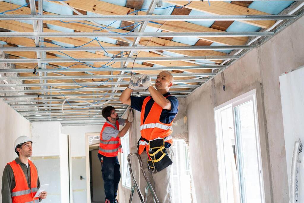 Skilled construction workers collaborate to install wiring and fixtures
